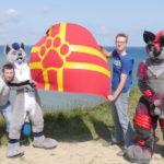 2 fursuiters et 2 hommes membres de normandifurs sur la falaise d'arromanches